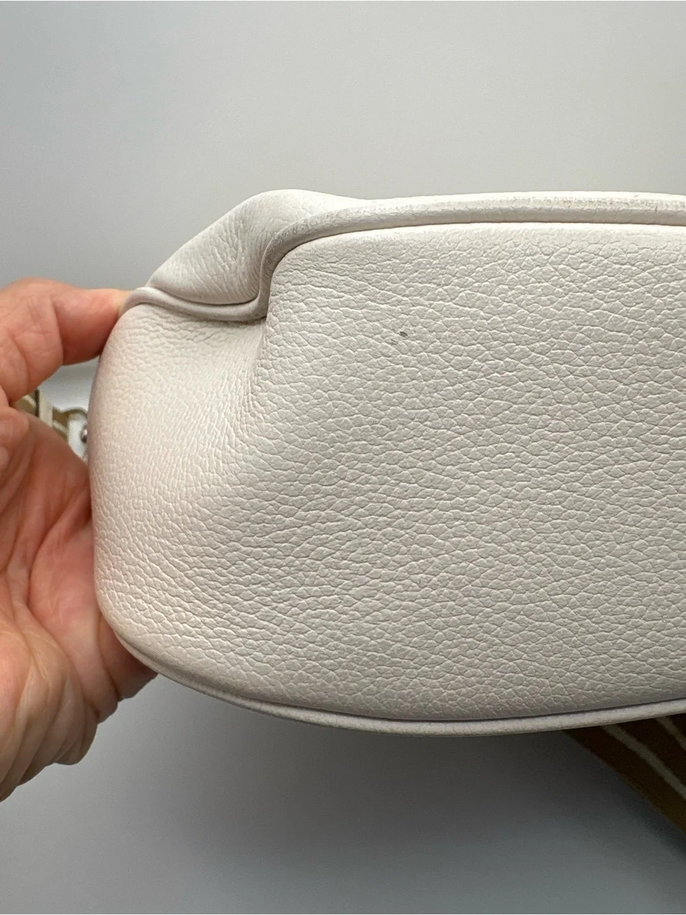 Kate Spade New York cream leather crossbody bag featuring a striped webbing Stra